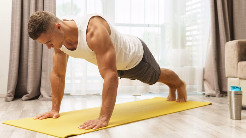 Tired middle-aged man looking discouraged while trying to exercise at home.